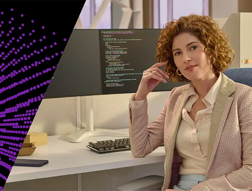 Professional woman sitting at her desk with coding on her computer screen