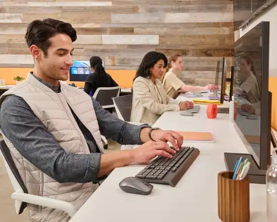 Plusieurs jeunes professionnels travaillant à leurs bureaux et souriant d'un air satisfait