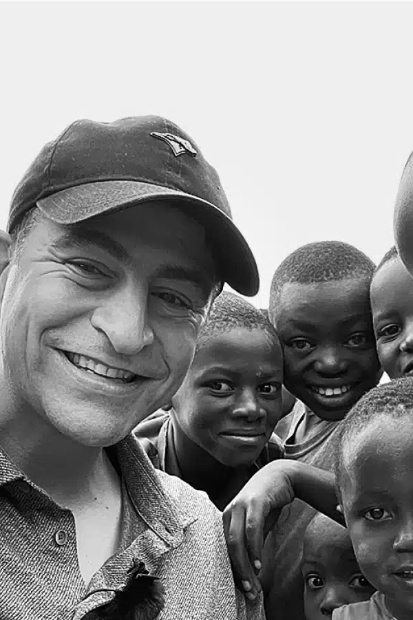Photo of Chris with children smiling and looking at the camera