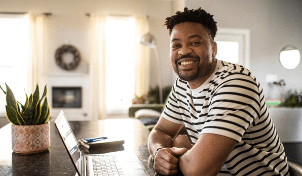 Male employee sitting at the counter in a black and white striped shirt