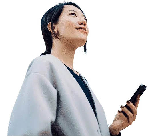 Mujer profesional sosteniendo su teléfono y mirando hacia el cielo