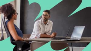 Male and female coworkers sitting at their workspace and discussing work