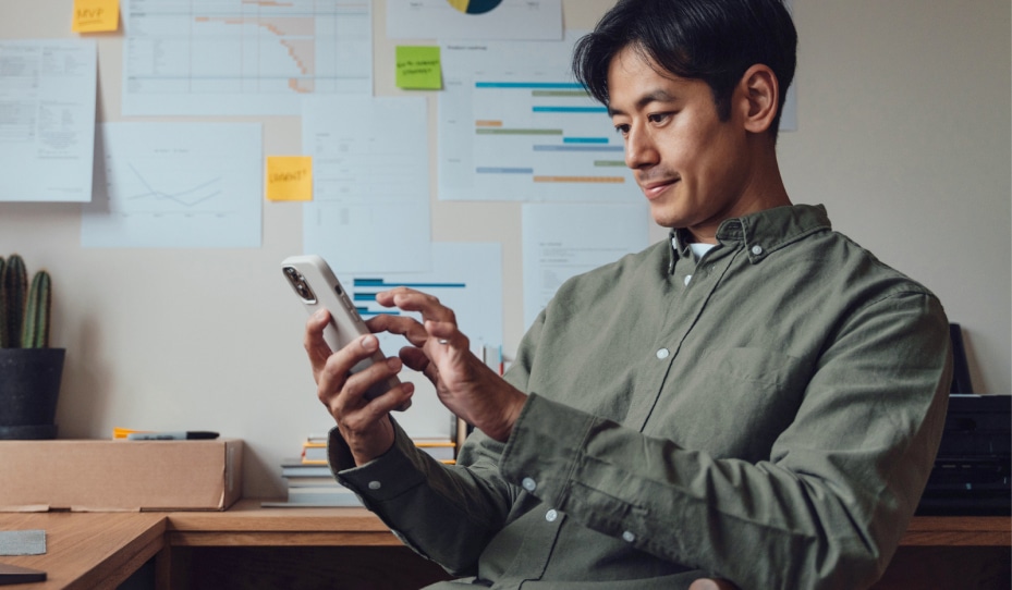Male employee sitting at his desk working on his phone