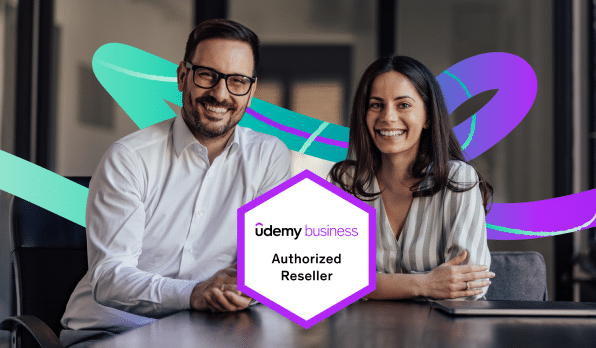 Two employees smiling and sitting together in business casual clothing