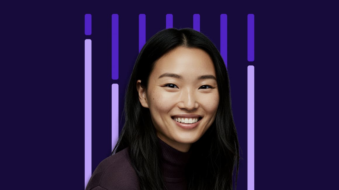 Female professional smiling and facing the camera in front of a digital background