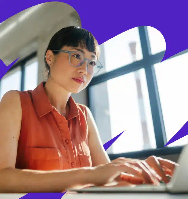 Woman with large glasses working on her laptop